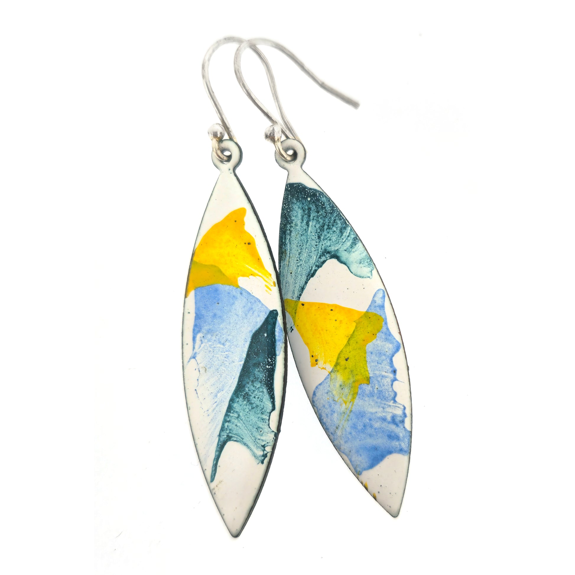 Boat shaped shaped enamel drop earrings with green, blue and yellow splashes on a white background. On silver ear hooks.