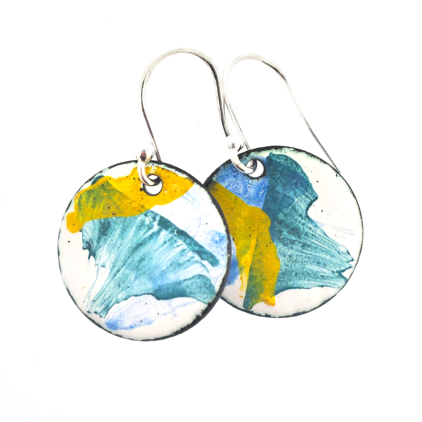 Round enamel drop earrings with splashes of blue, green and yellow on a white background. On silver ear hooks.