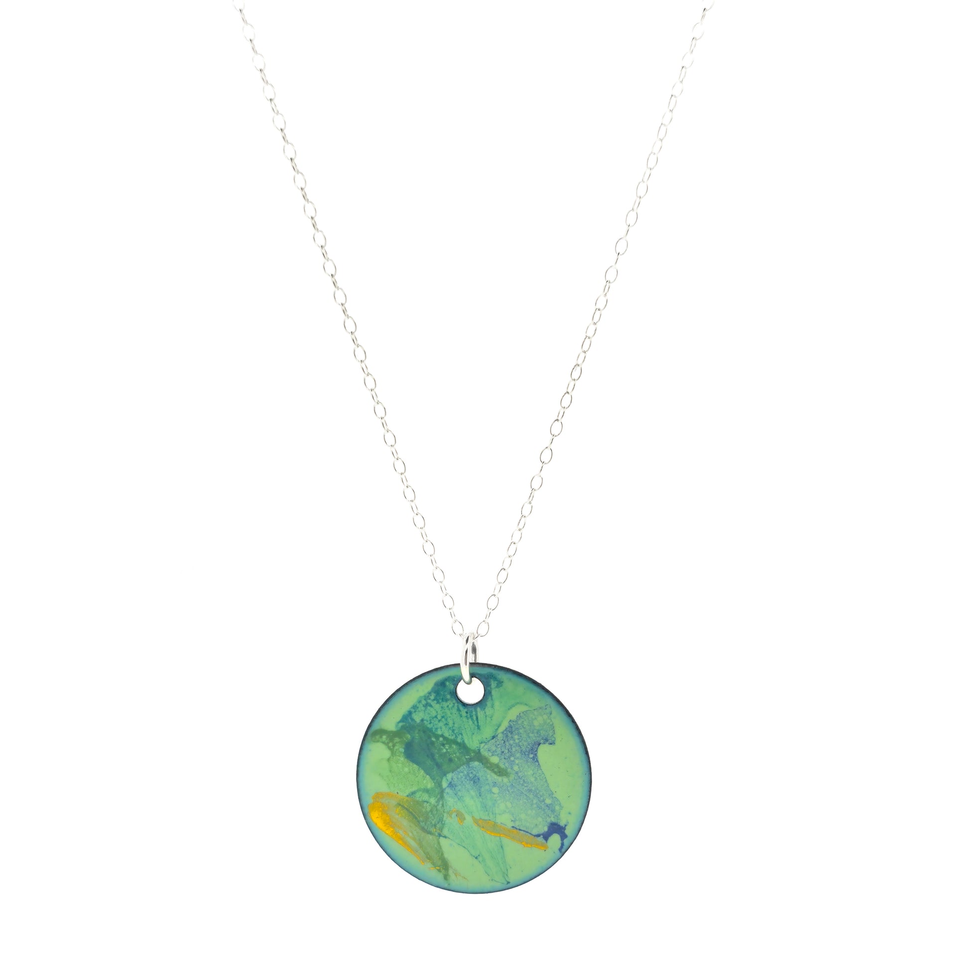 A round enamel pendant with a green background with splashes of dark green, blue and yellow. Suspended on a silver chain.