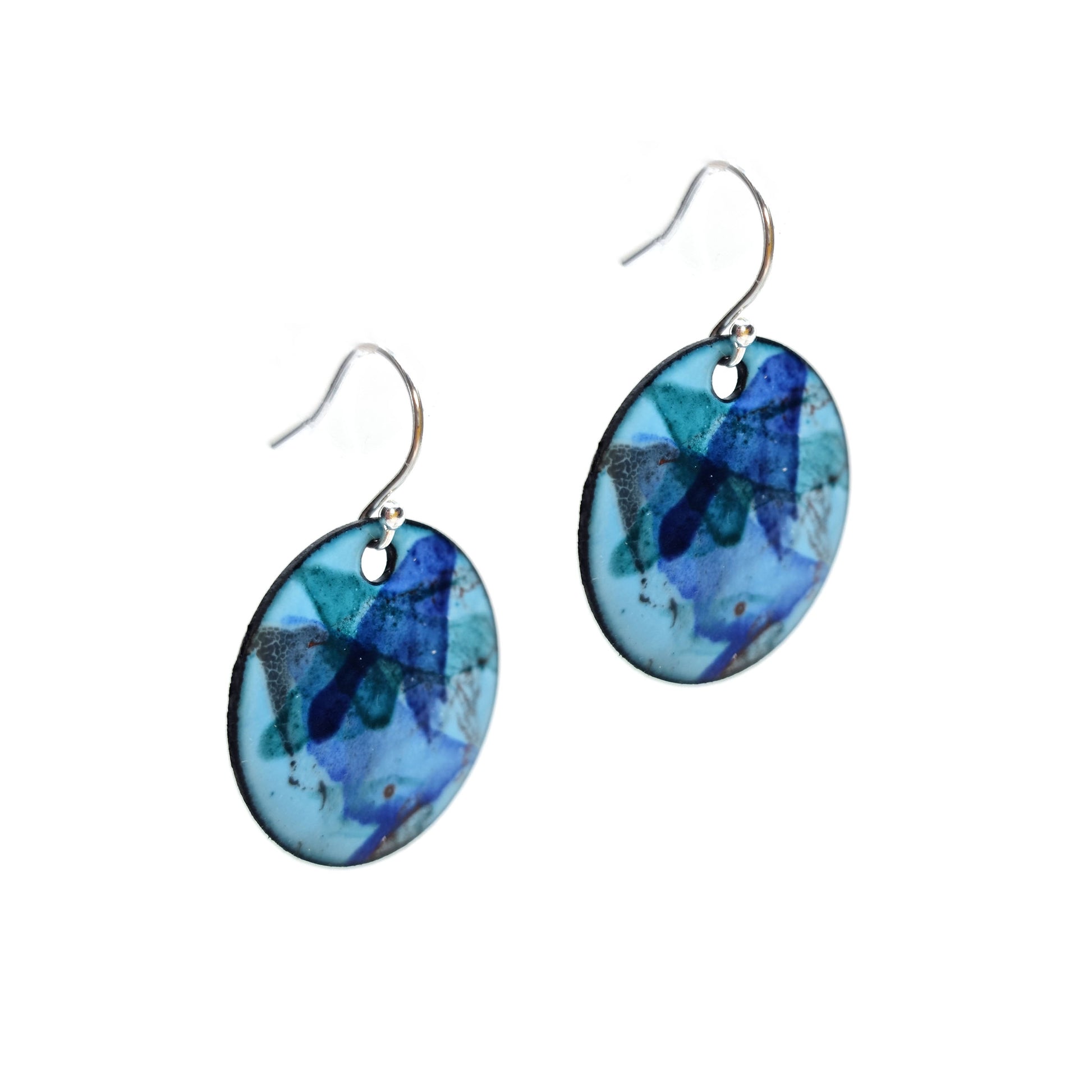 Round enamel drop earrings with splashes of dark blue, green, grey and red on a light blue background.