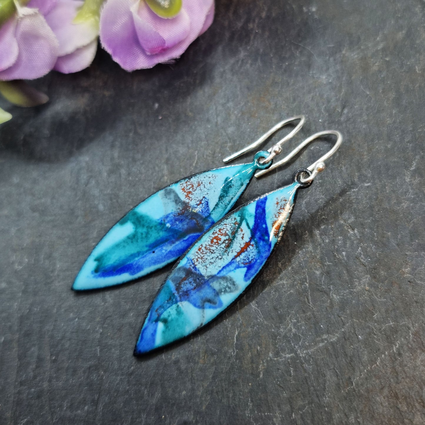 Navette shaped blue enamel drop earrings with splashes of grey, red and dark blue.