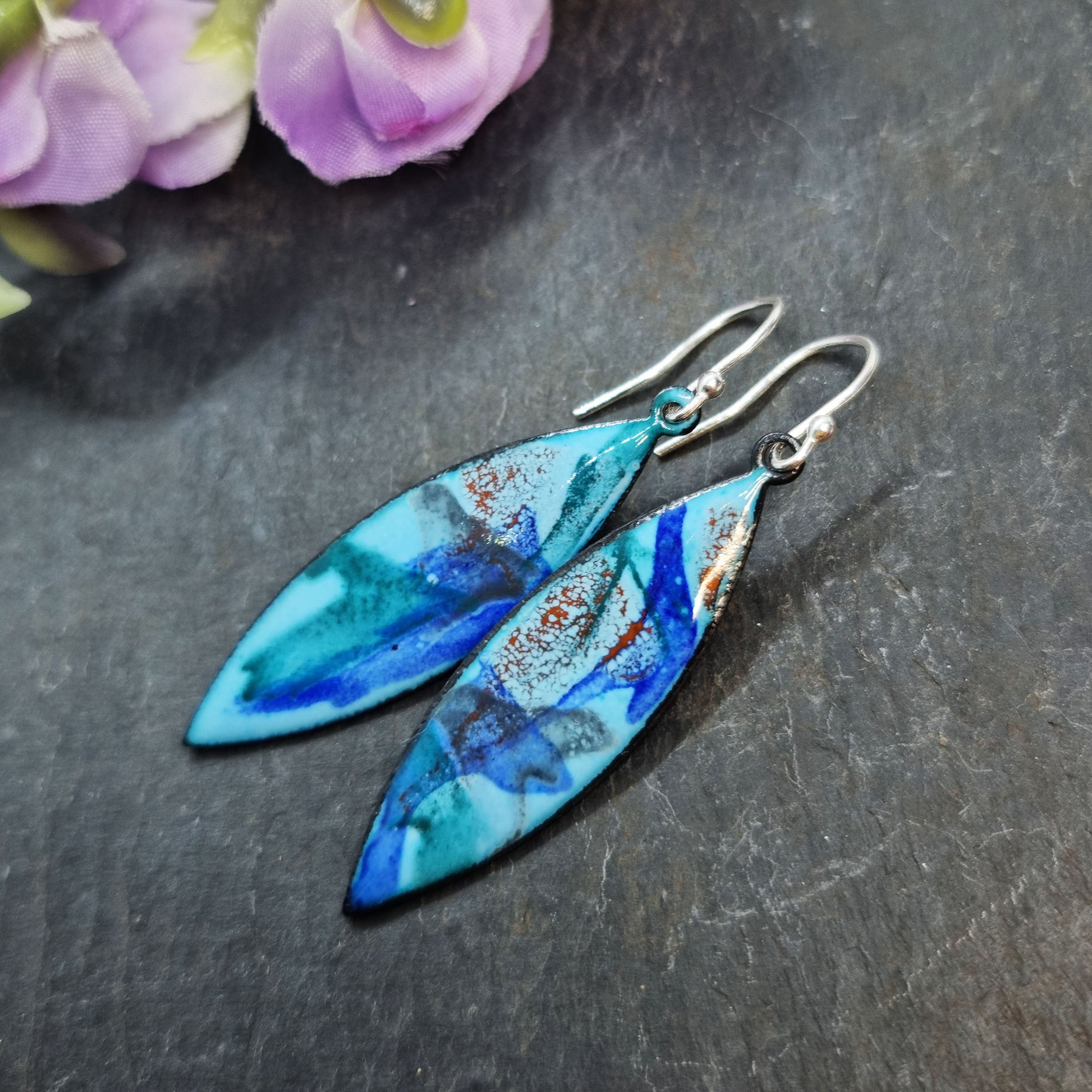 Navette shaped blue enamel drop earrings with splashes of grey, red and dark blue.