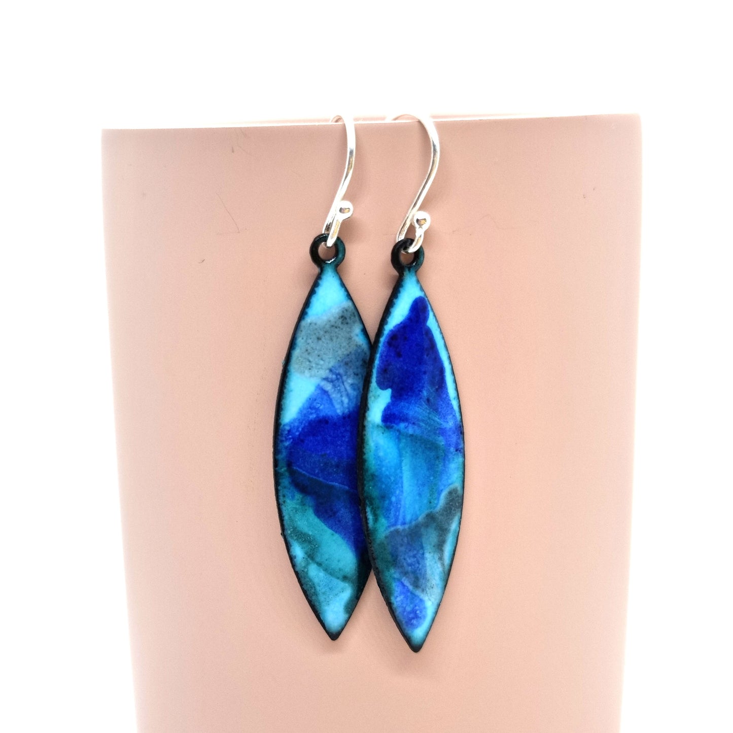 Navette shaped blue enamel drop earrings with splashes of grey and dark blue.