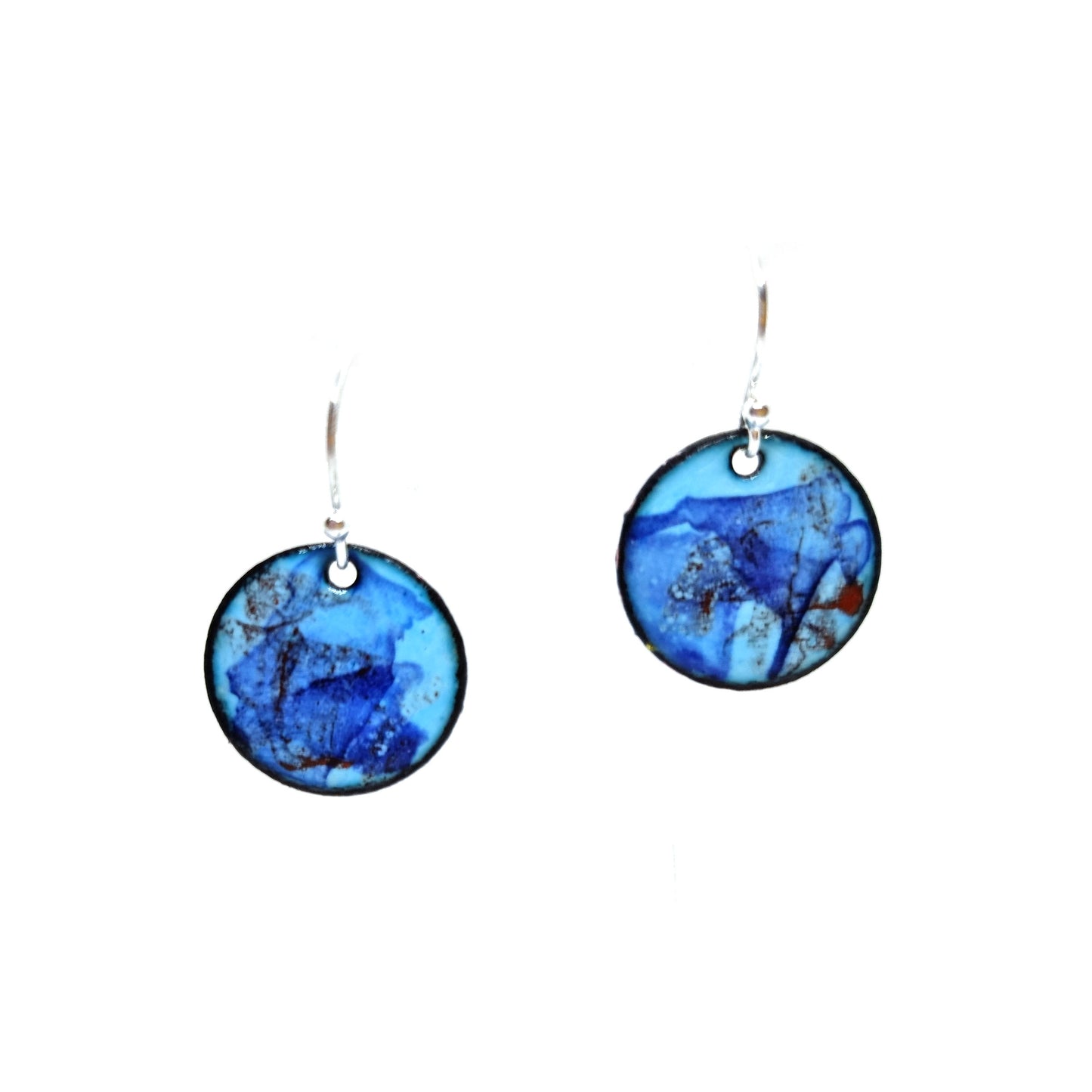 Round enamel drop earrings with splashes of dark blue and red on a light blue background.