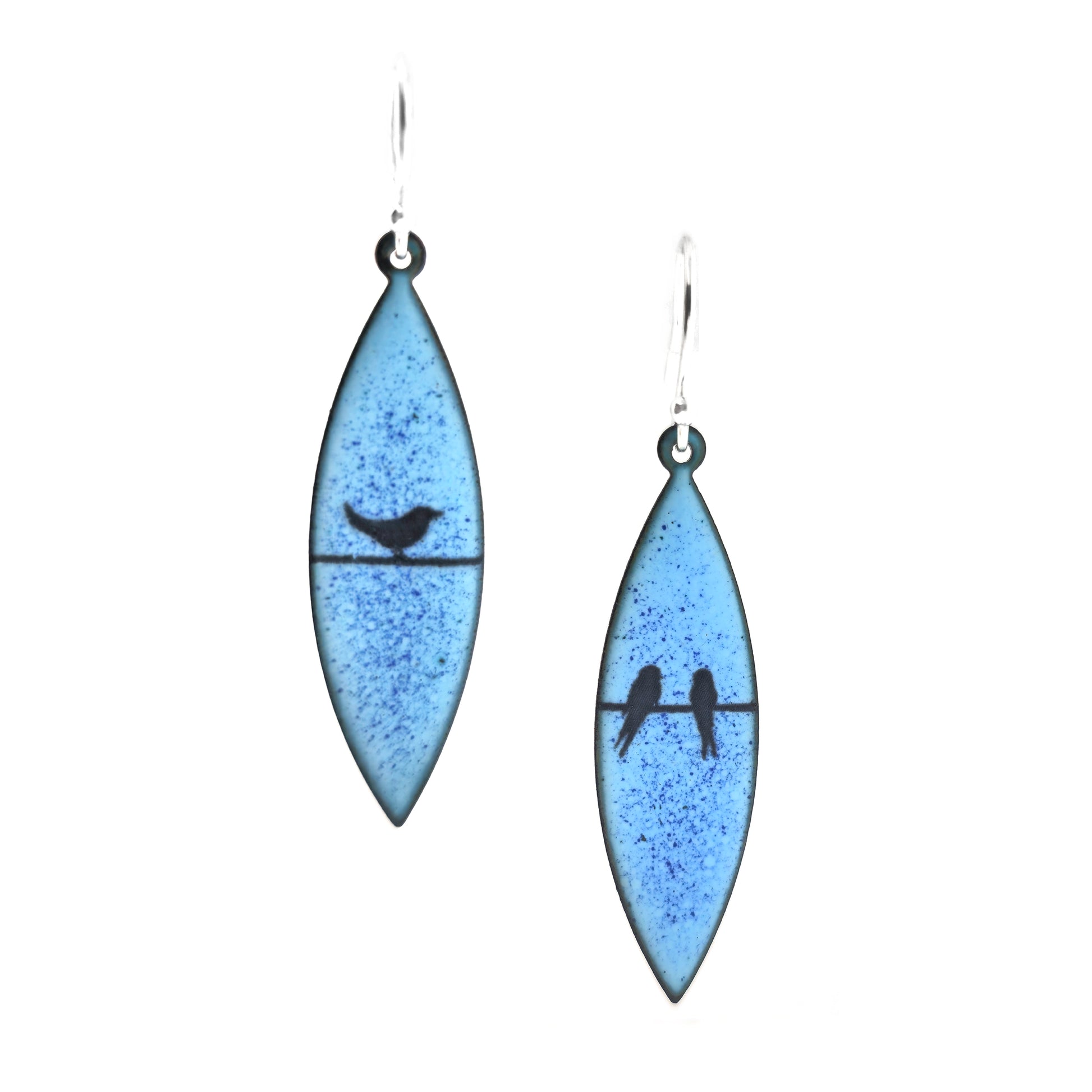 Boat-shaped enamel drop earrings with black coloured bird silhouettes sitting on a wire on a blue background