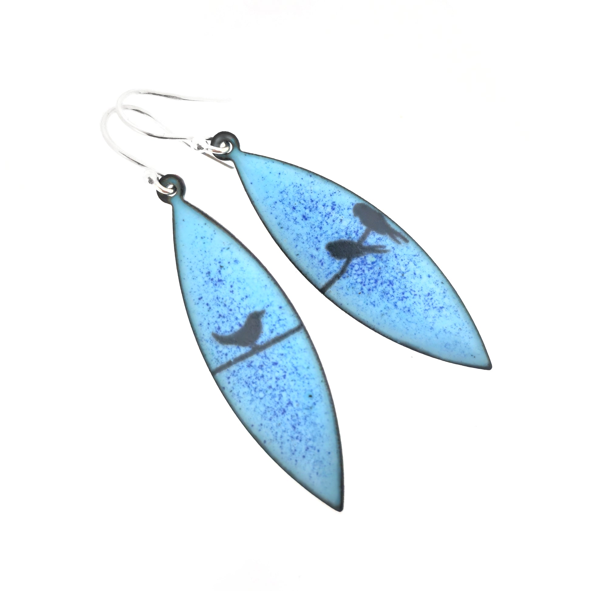 Boat-shaped enamel drop earrings with black coloured bird silhouettes sitting on a wire on a blue background