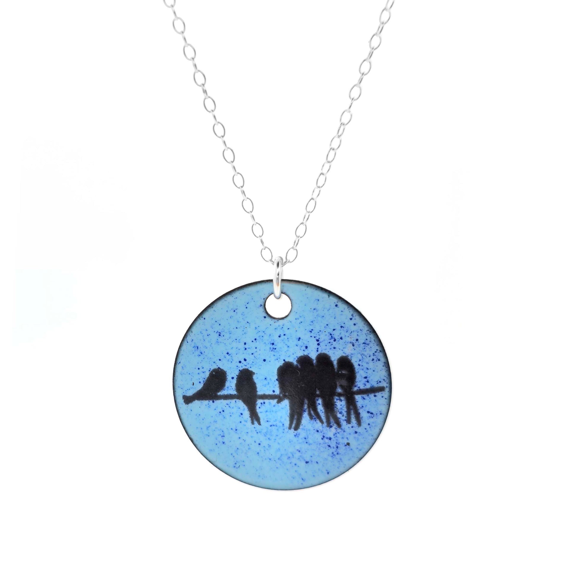 Round blue enamel pendant with birds on a wire, on a silver chain on a white background.