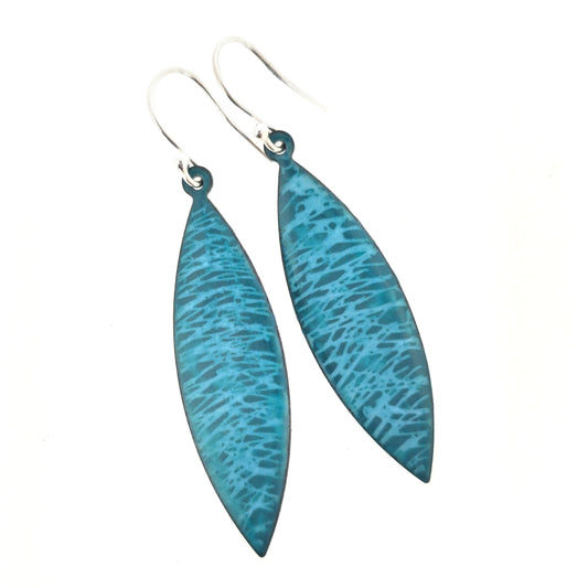 Boat-shaped drop earrings featuring a scatter line pattern in light blue and teal enamel. Suspended from silver ear hooks.