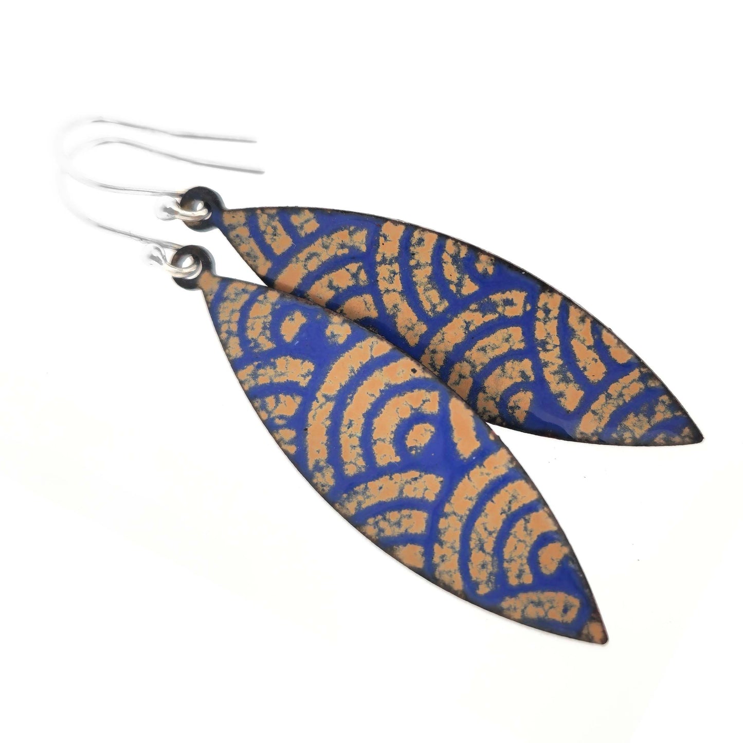 Pair of blue and gold enamel patterned earrings with silver ear hooks on a white background