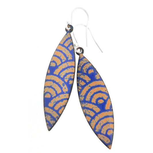 Pair of blue and gold enamel patterned earrings with silver ear hooks on a white background