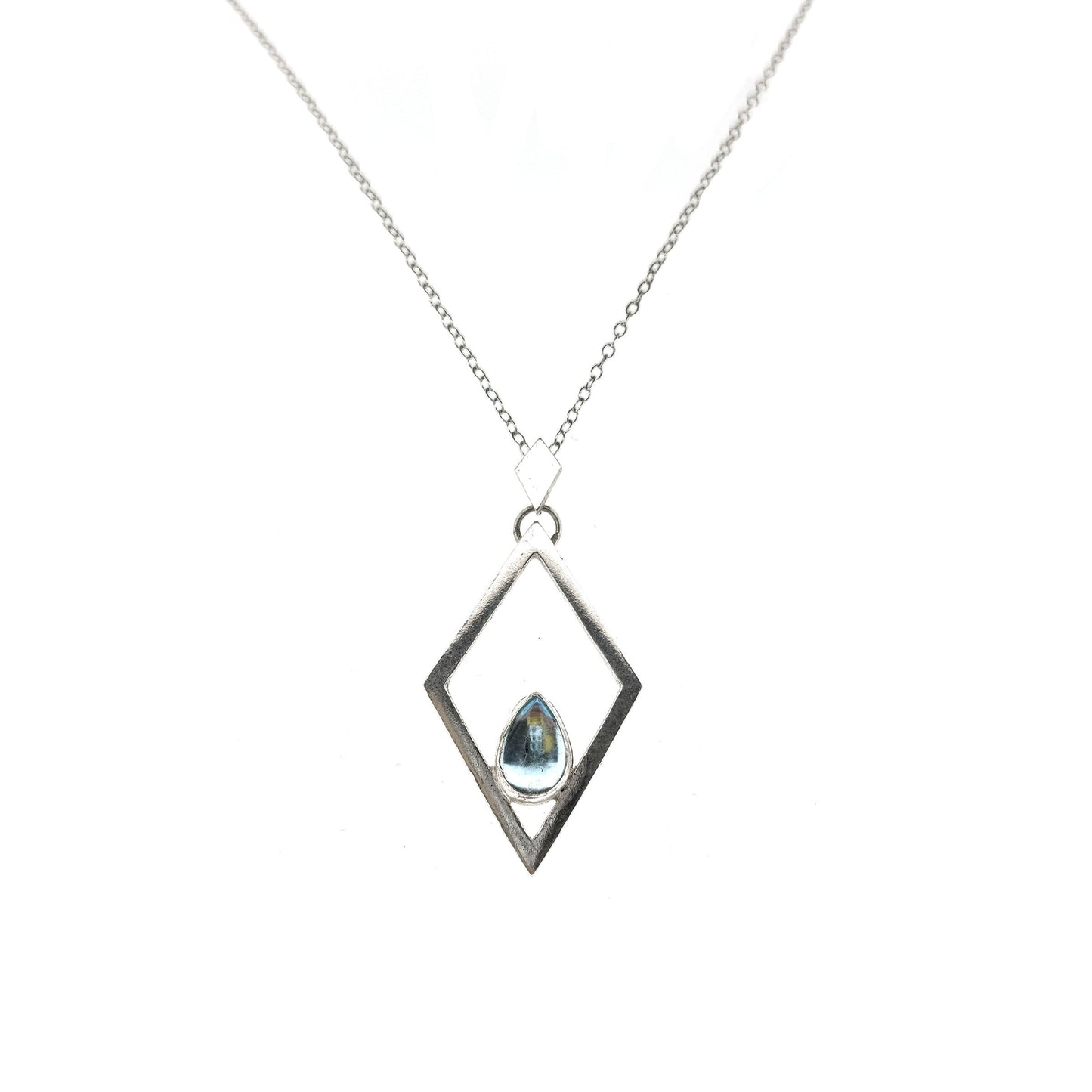 A silver open diamond shaped pendant with a teardrop shaped blue topaz gemstone set inside. A small diamond shaped bail attaches the pendant to a silver chain.