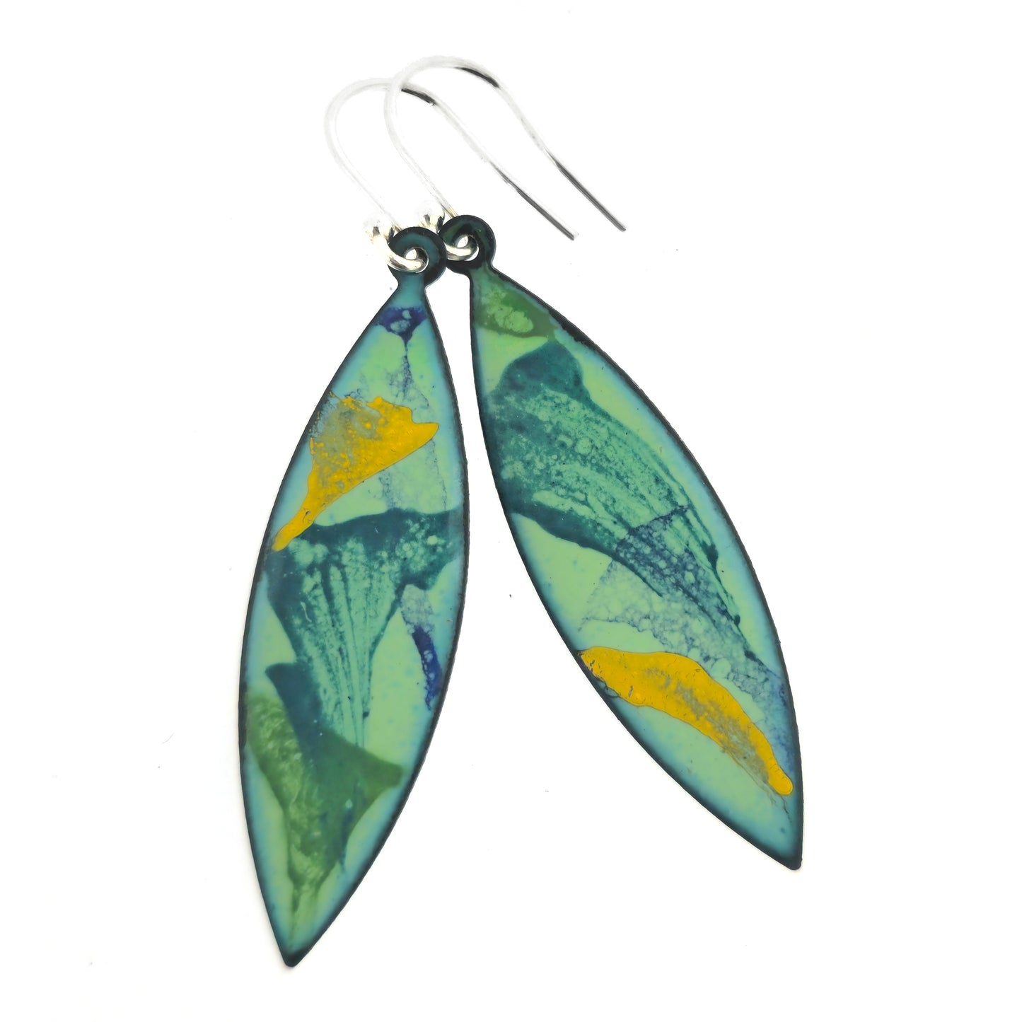 Boat shaped enamel drop earrings on silver ear hooks, consisting of splashes of dark green, dark blue and yellow on a light green background.