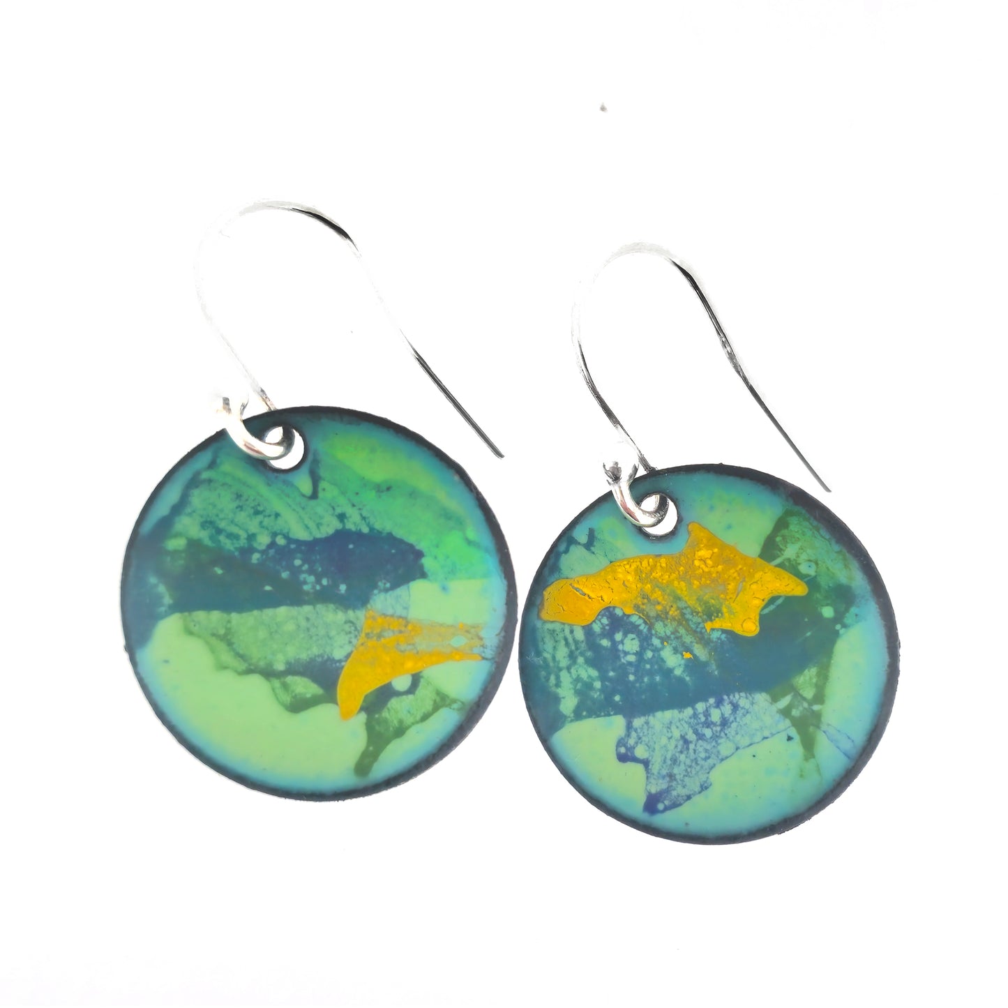 Round enamel drop earrings with splashes of blue, green and yellow on a light green background