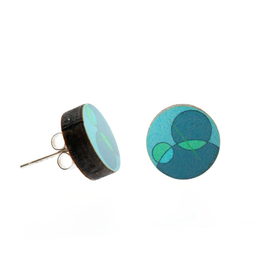 Round stud earrings made of wood with a green and turquoise circle retro-style pattern.
