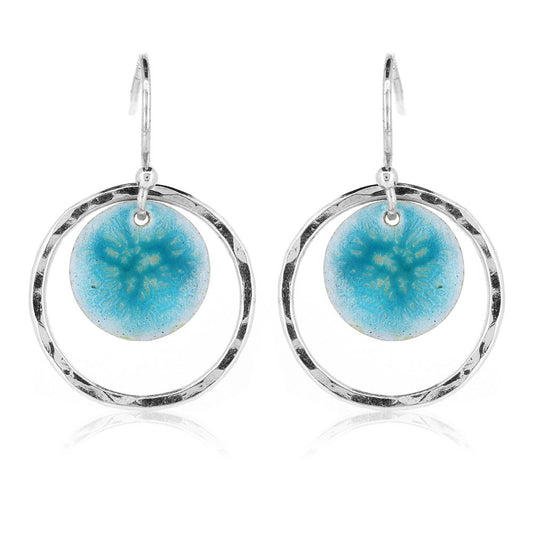 Silver drop earrings with a central silver disc covered with a turquoise enamel pattern and a surrounding hammered silver circle.