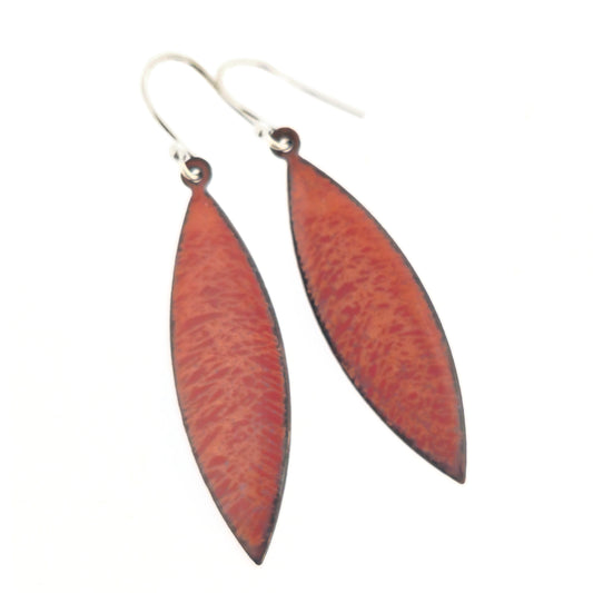 Boat-shaped drop earrings with a scatter line pattern in orange and red enamels. Suspended from silver ear hooks.