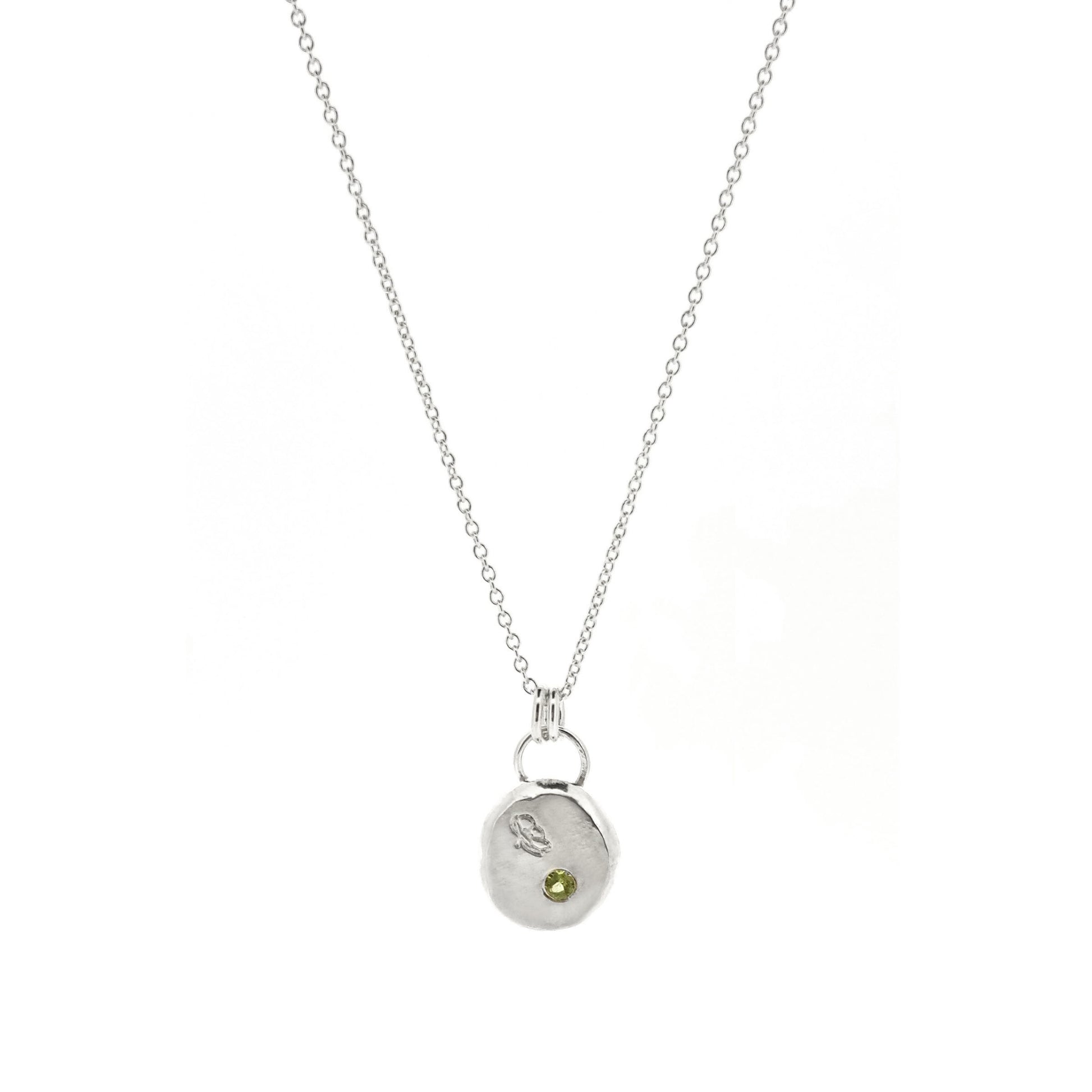 Silver round flat 'pebble' birthstone pendant with a poppy engraved on it and a pale green peridot gemstone on a silver chain. - August