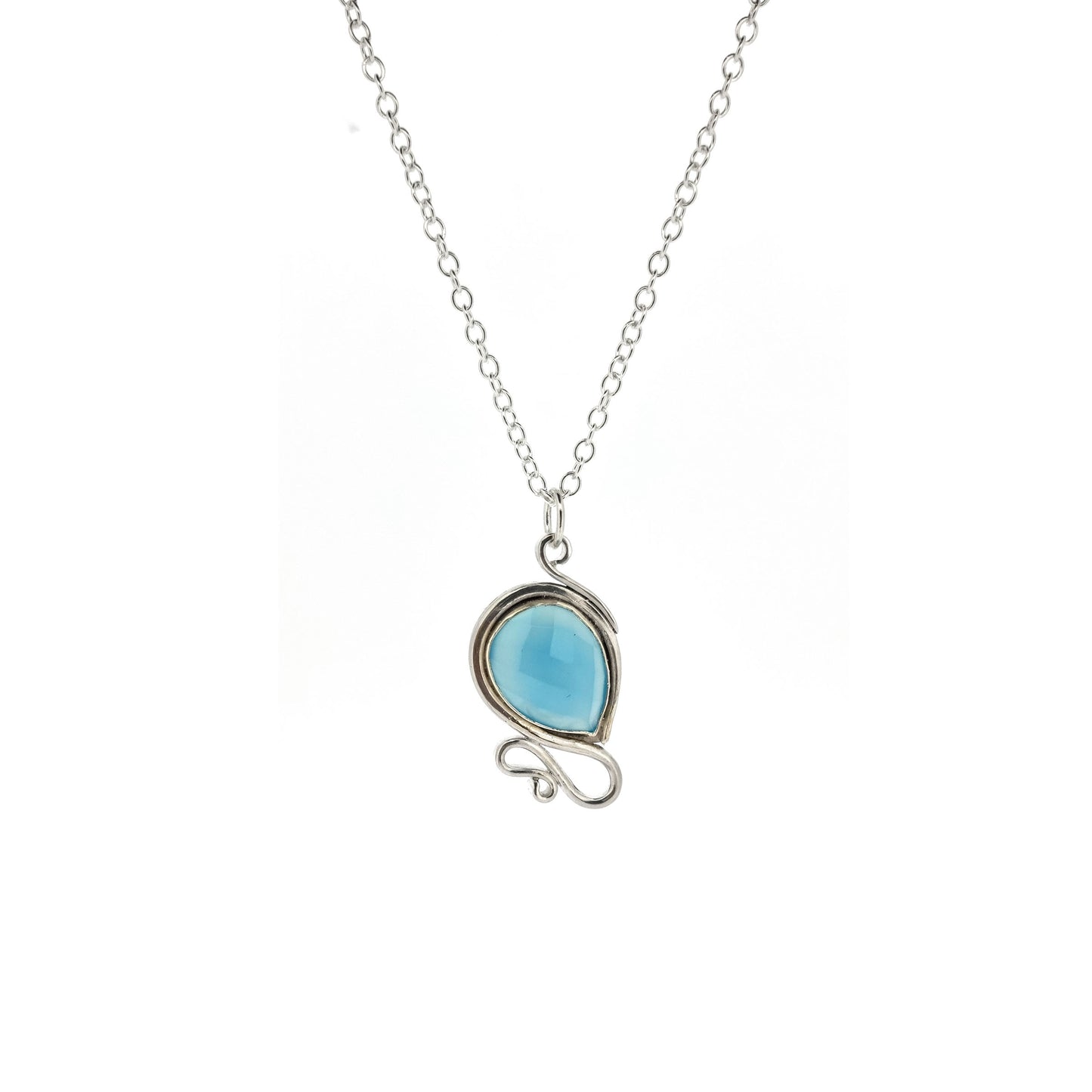 Silver pendant necklace with a teardrop shaped turquoise blue chalcedony gemstone surrounded by a silver bezel and with silver swirls above and below. On a silver chain.