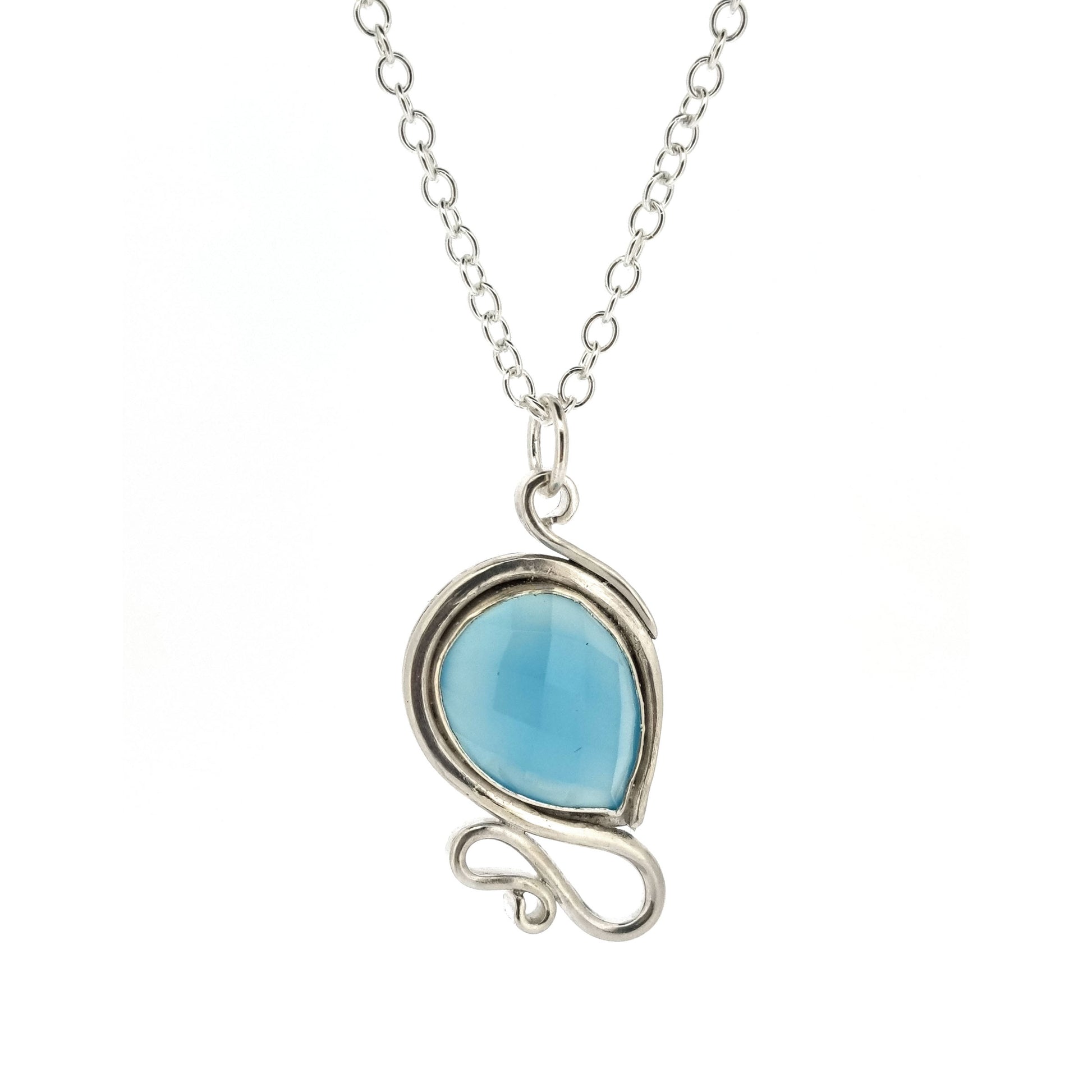 Silver pendant necklace with a teardrop shaped turquoise blue chalcedony gemstone surrounded by a silver bezel and with silver swirls above and below. On a silver chain.