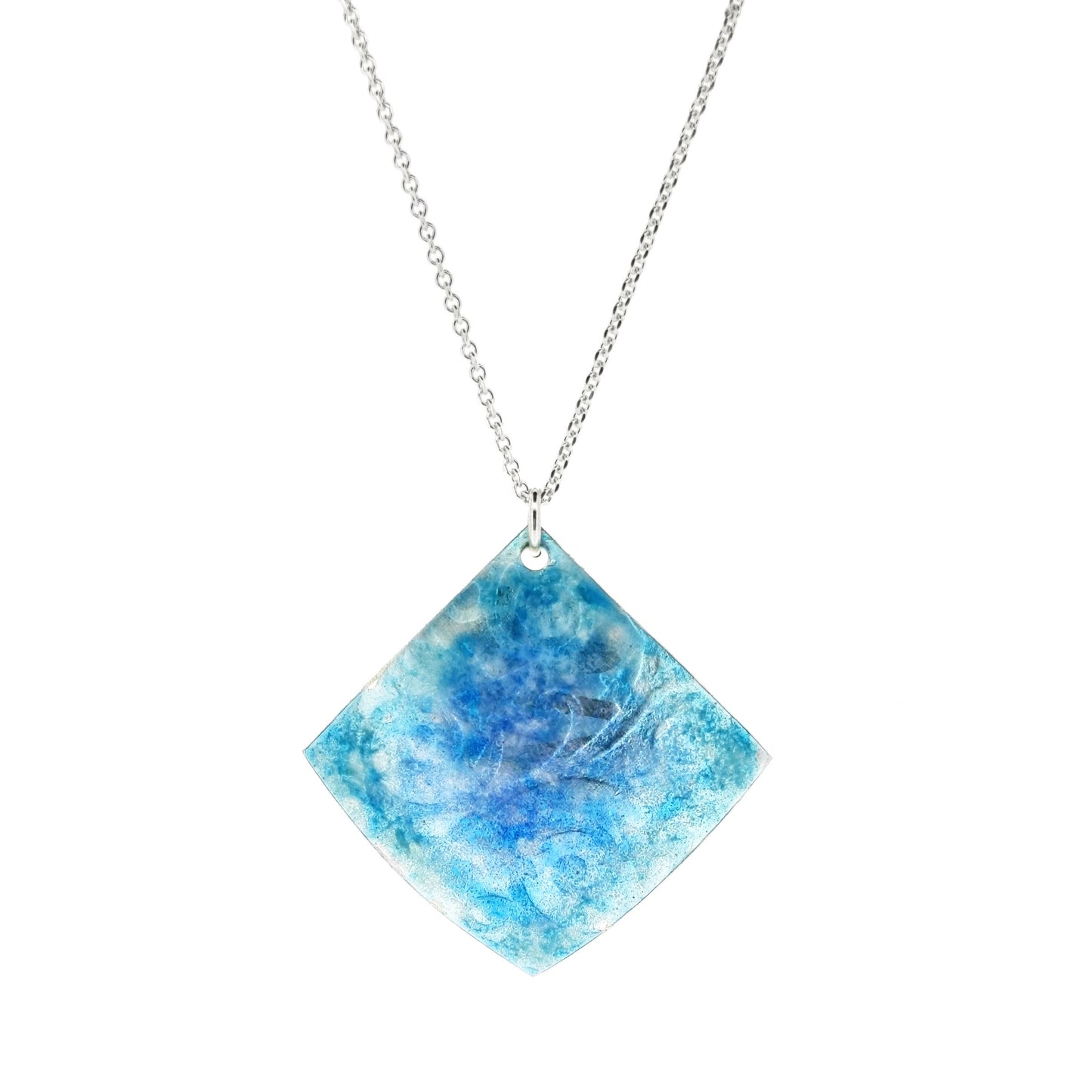 A curved square silver pendant with stars and swirls embossed on it and overlaid with blue and turquoise enamels. Suspended on a silver chain.