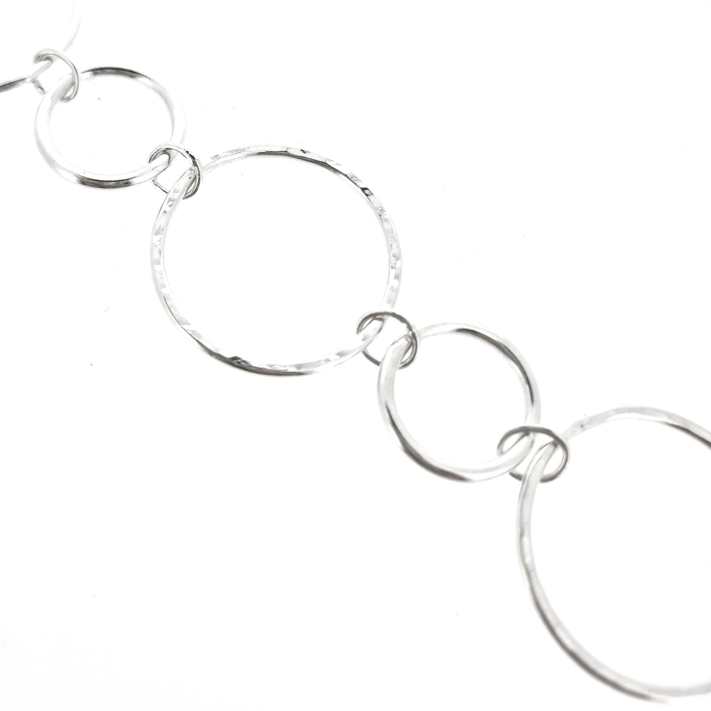 Silver chain link bracelet with 2 sizes of circles, one size has a hammered finish
