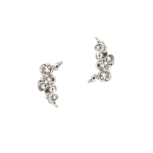 A pair of silver curved earrings made up of balls and gemstones.