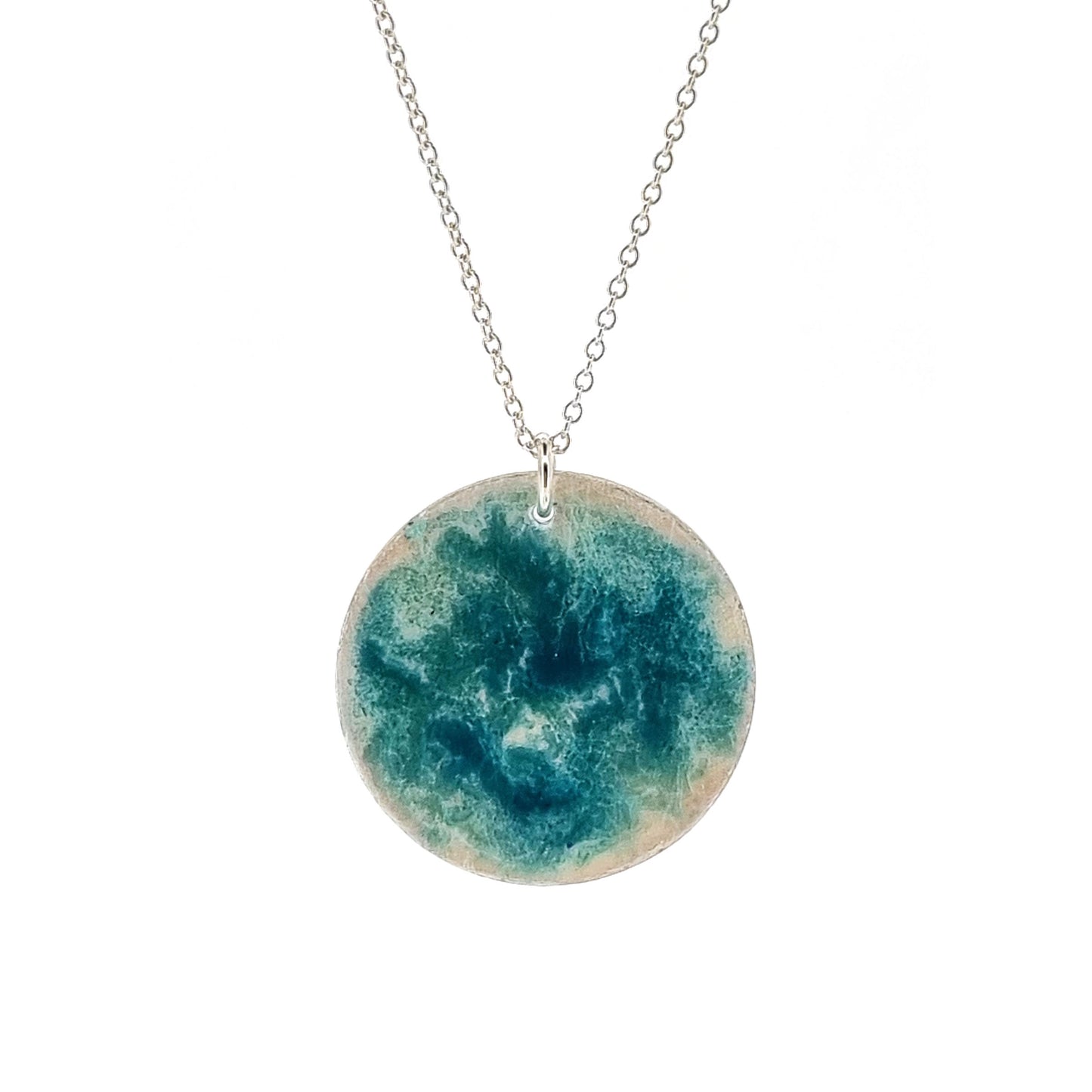 Round silver pendant with turquoise swirl enamel pattern. On silver chain.
