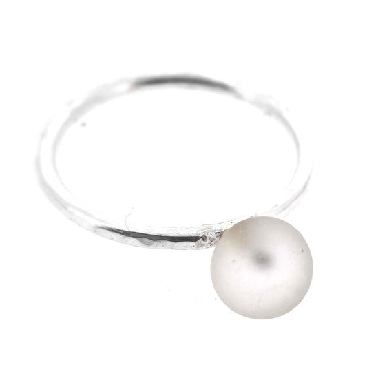 A ring made up of a thin silver band with a hammered finish and a white glass sphere on top. Mijoux Creations.