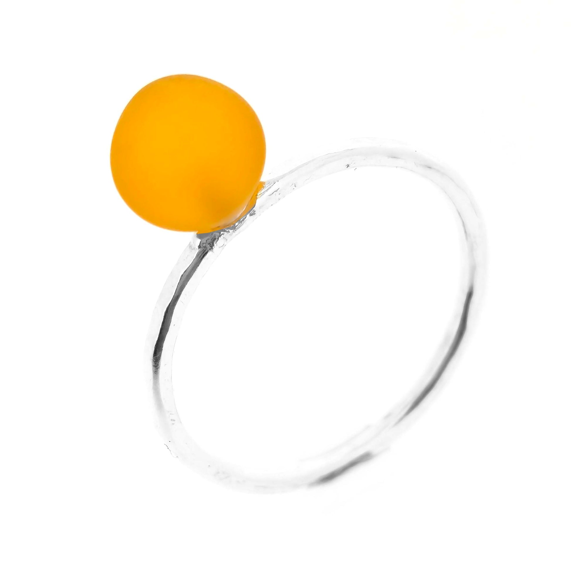 A silver ring with a thin band with a hammered finish and an orange glass sphere on top. Mijoux Creations