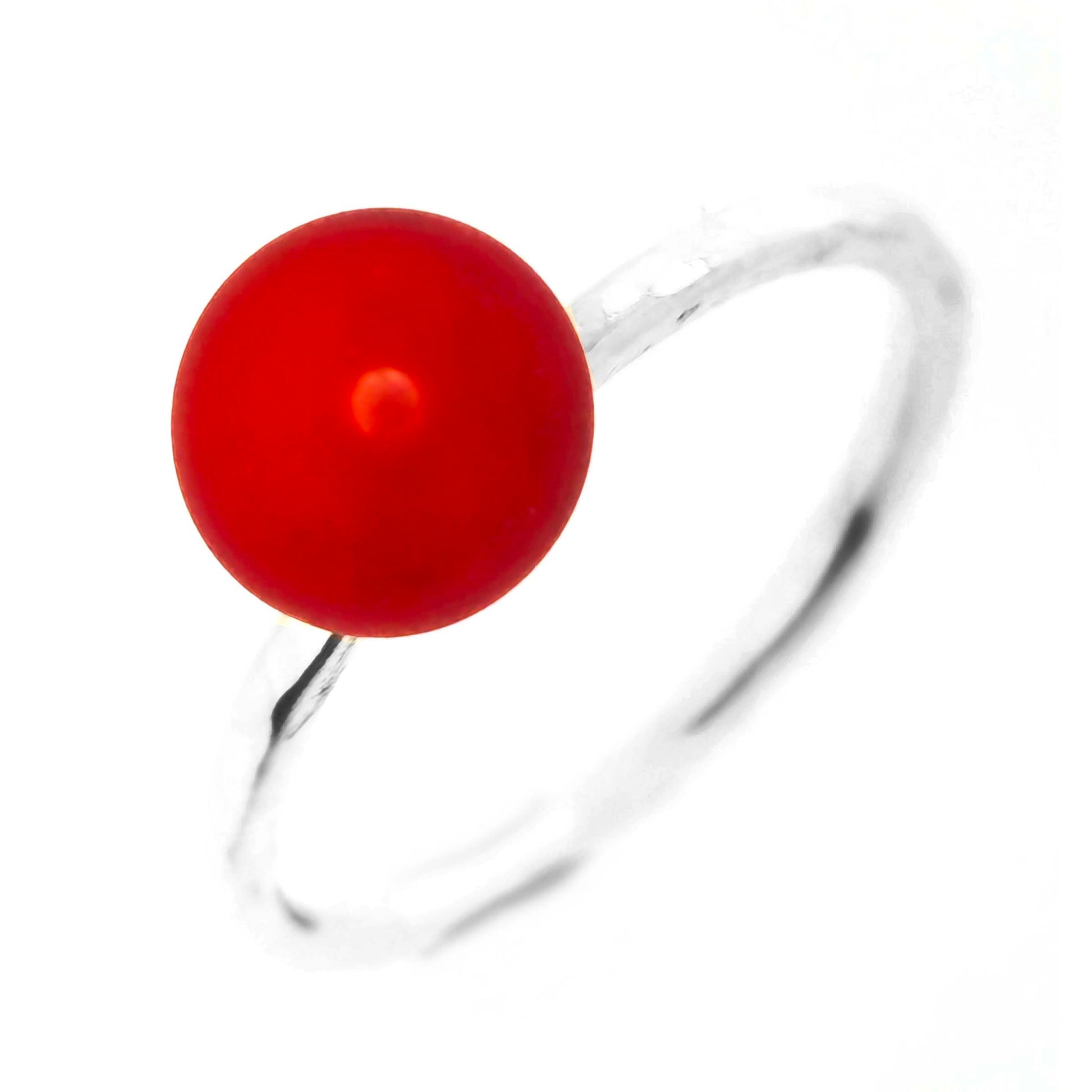 A silver ring with a thin hammered silver band and a red glass sphere on top. Mijoux Creations.