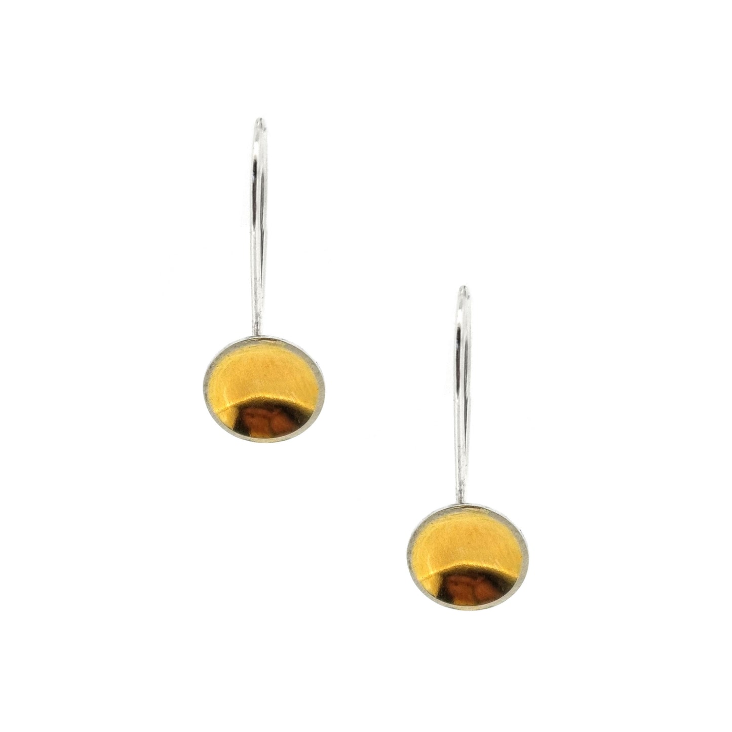 Silver drop earrings with a domed round section with a gold center suspended from a silver ear wire.