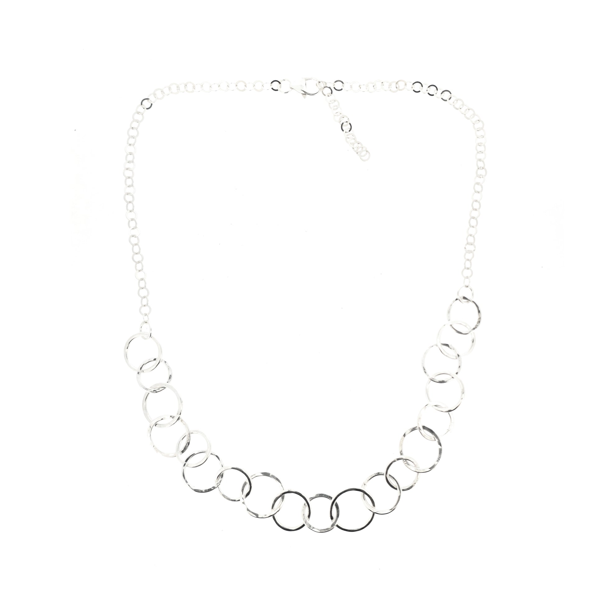 A silver necklace made up of different size circles with a hammered finish and smaller silver chain at the back.