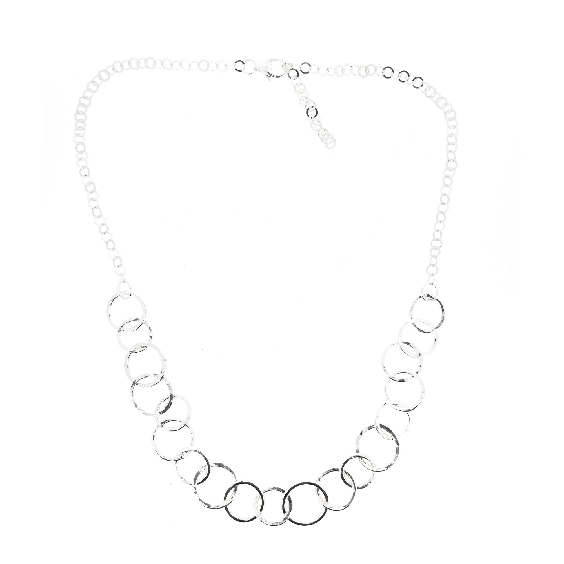 A silver necklace made up of different size circles with a hammered finish and smaller silver chain at the back.