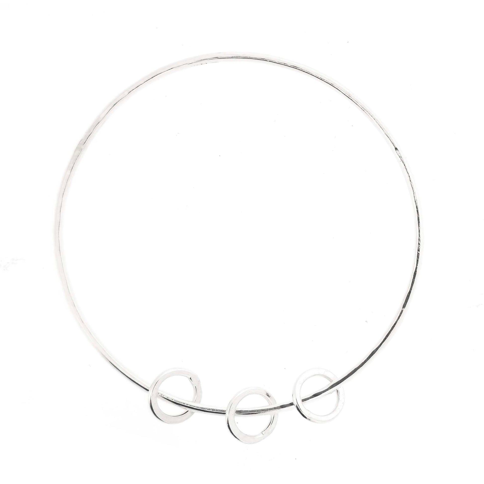 Silver textured bangle with 3 circle beads on a white background