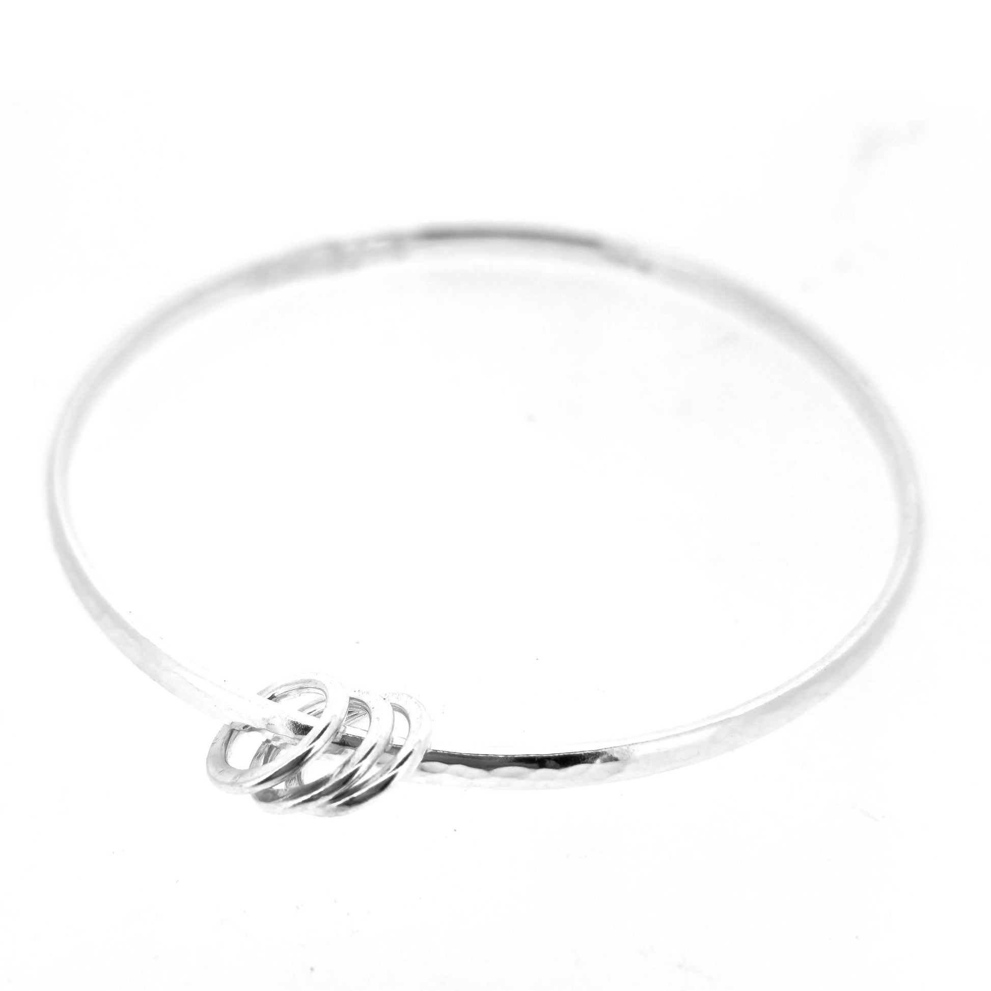 Silver textured bangle with 3 circle beads on a white background