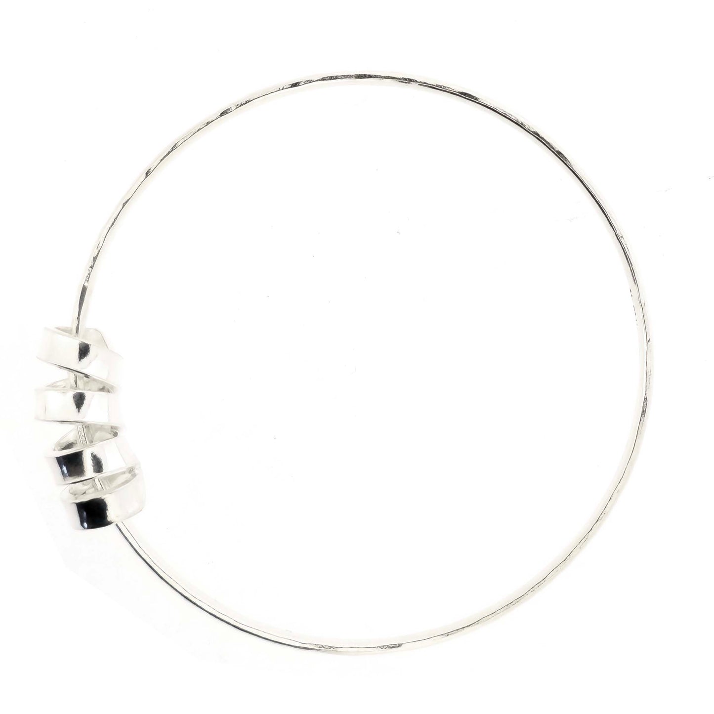 Silver bangle with a hammered finish and a wide spiral bead on a white background.