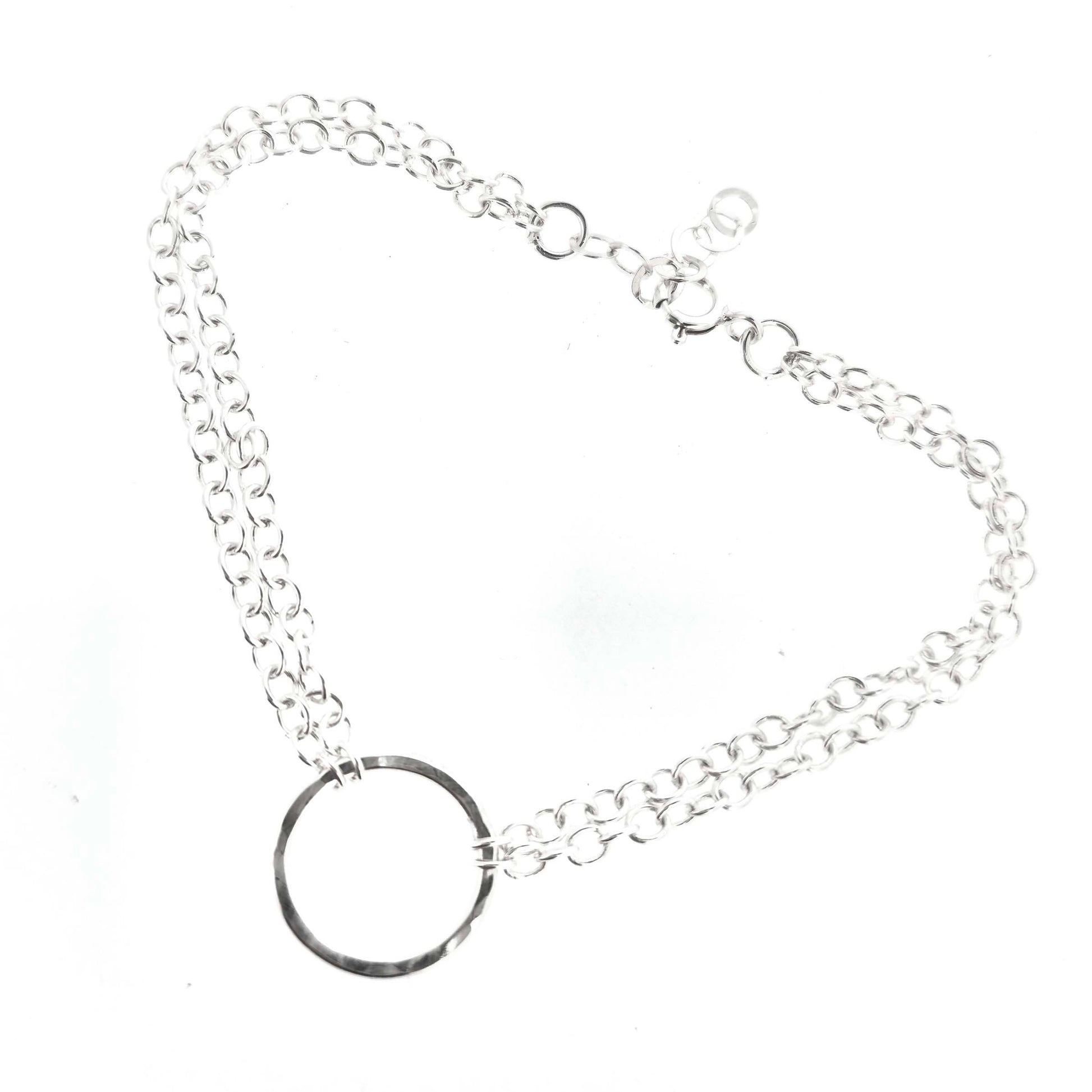 Silver double chain bracelet with a central hammered circle on a white background