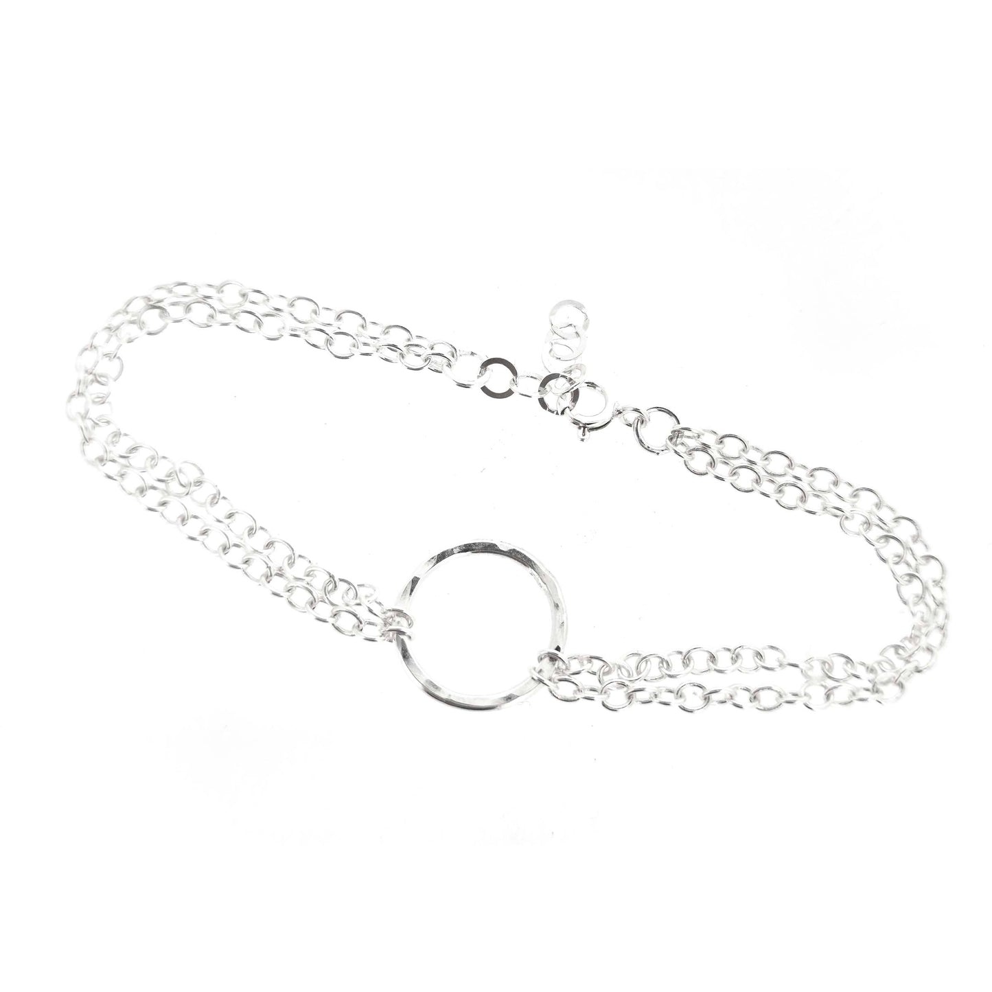 Silver double chain bracelet with a central hammered circle on a white background