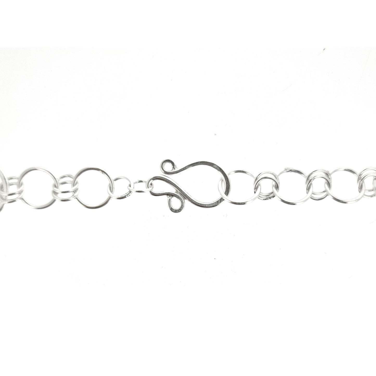 Silver chain with circular links and an s clasp.