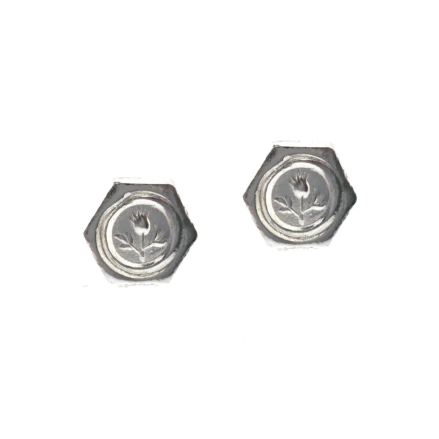 A pair of hexagon shaped sterling silver stud earrings with a thistle on them.