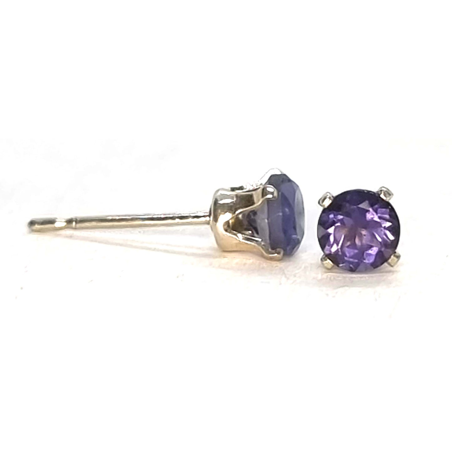 Pair of purple gemstone stud earrings on a white background