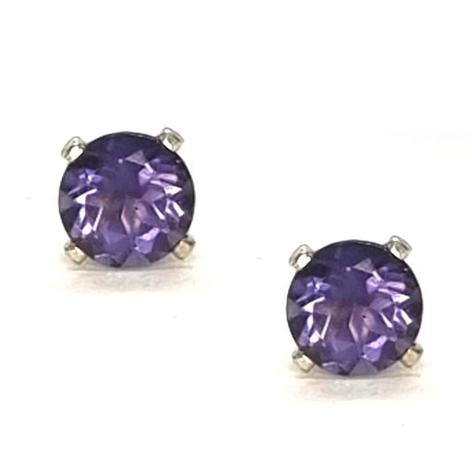 Pair of purple gemstone stud earrings with a 4 claw setting on a white background