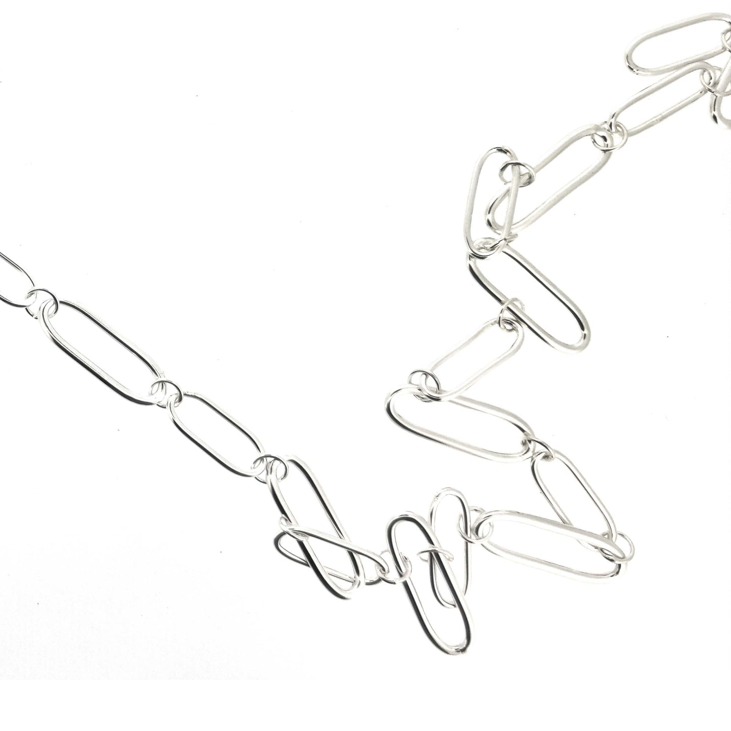 A silver chain necklace with open oblong links of different sizes.