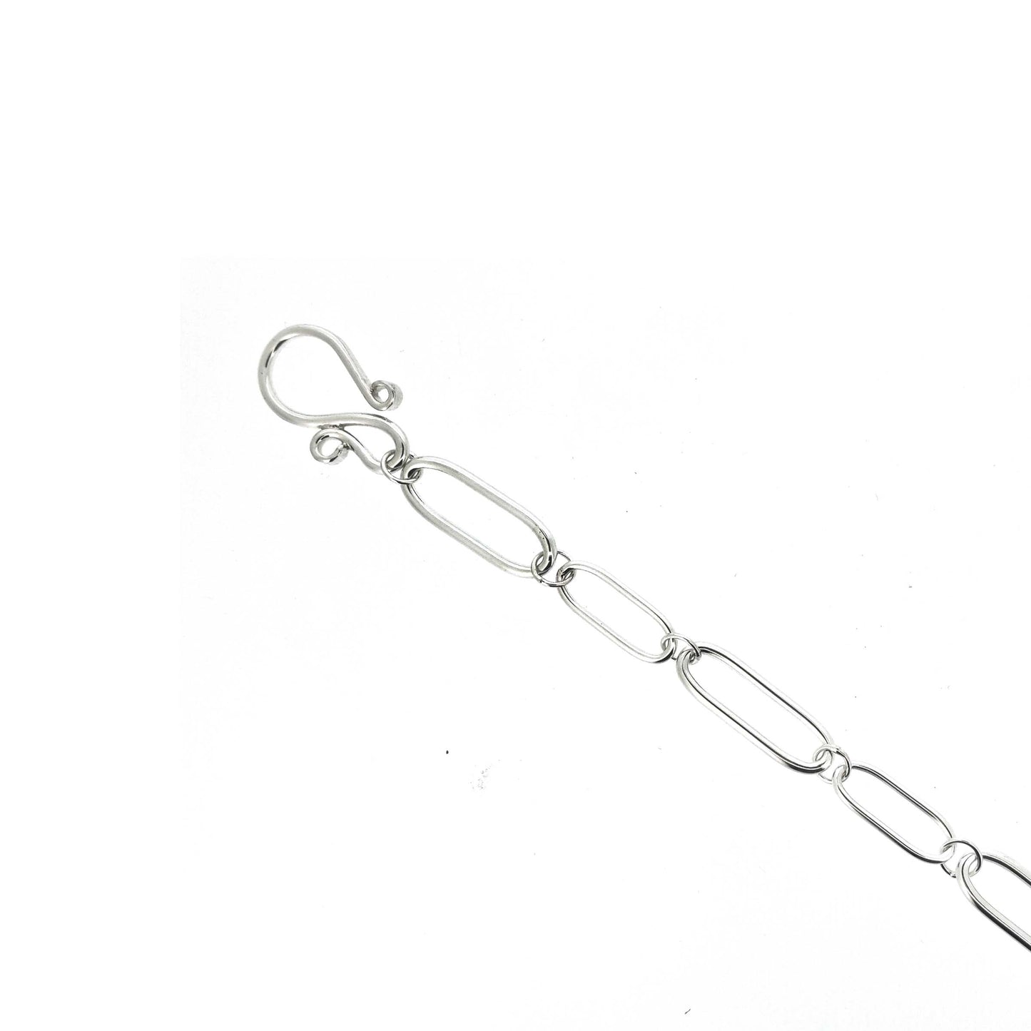 A silver chain necklace with open oblong links of different sizes and an s-clasp
