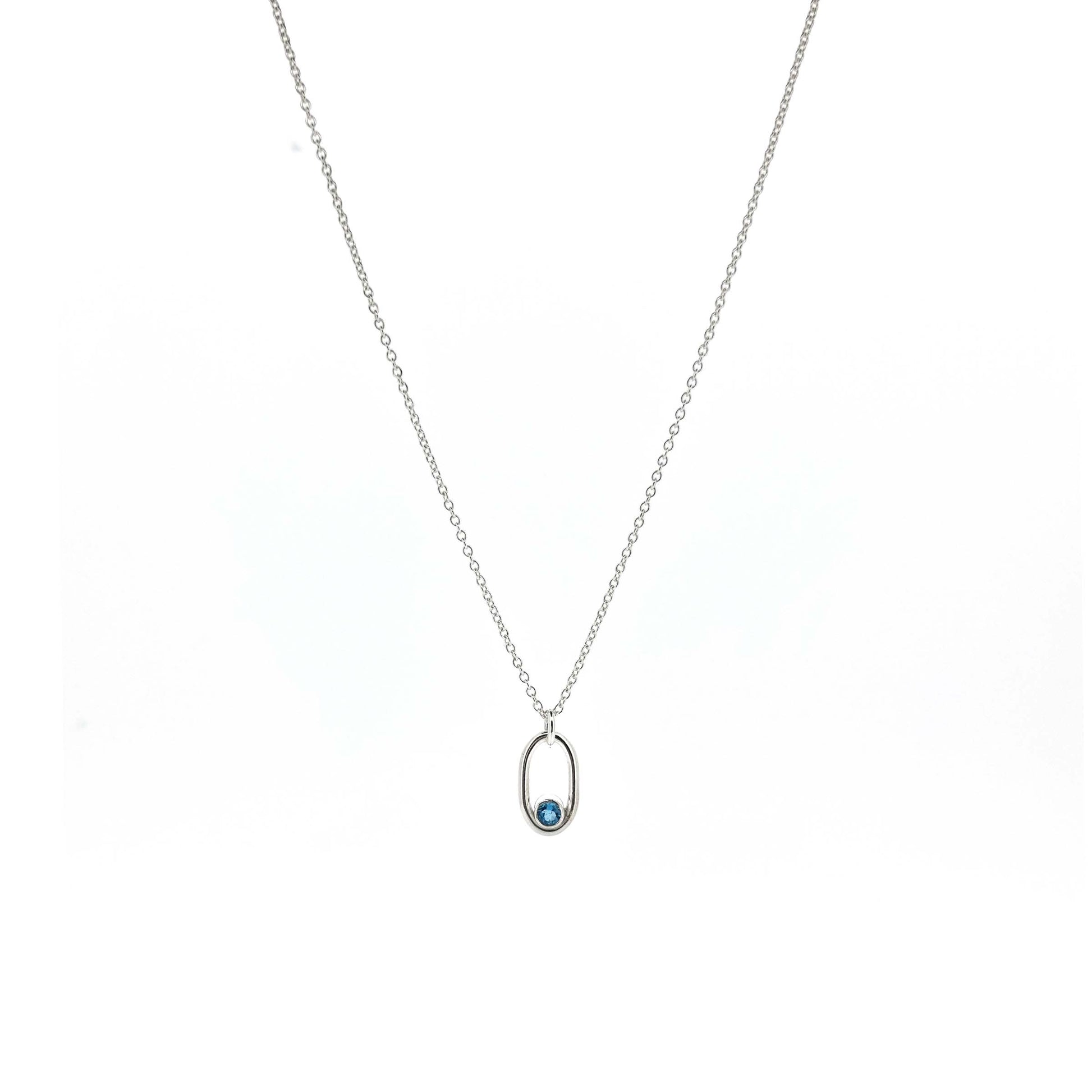Silver open oblong pendant with a blue topaz gemstone set in the curve on a silver chain.