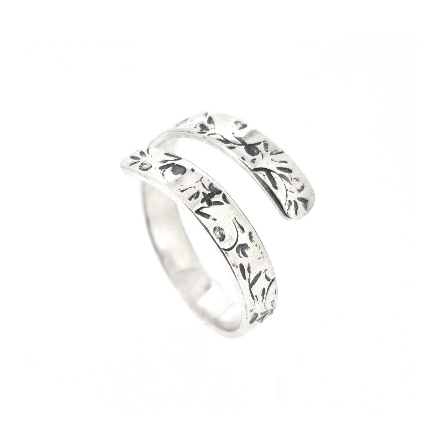 A flat silver wrap ring with leaf, bud and stalk pattern.