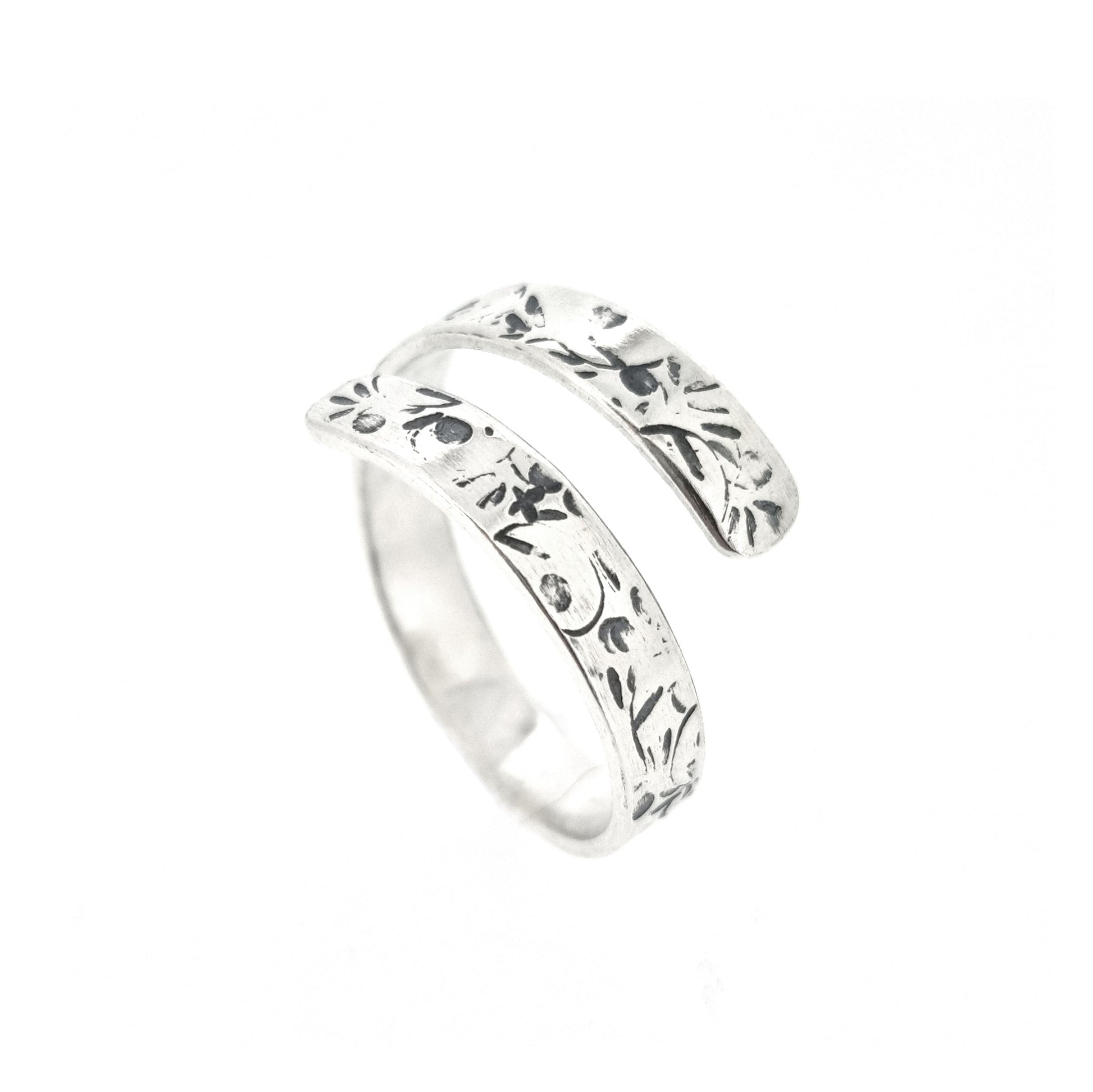 A flat silver wrap ring with leaf, bud and stalk pattern.