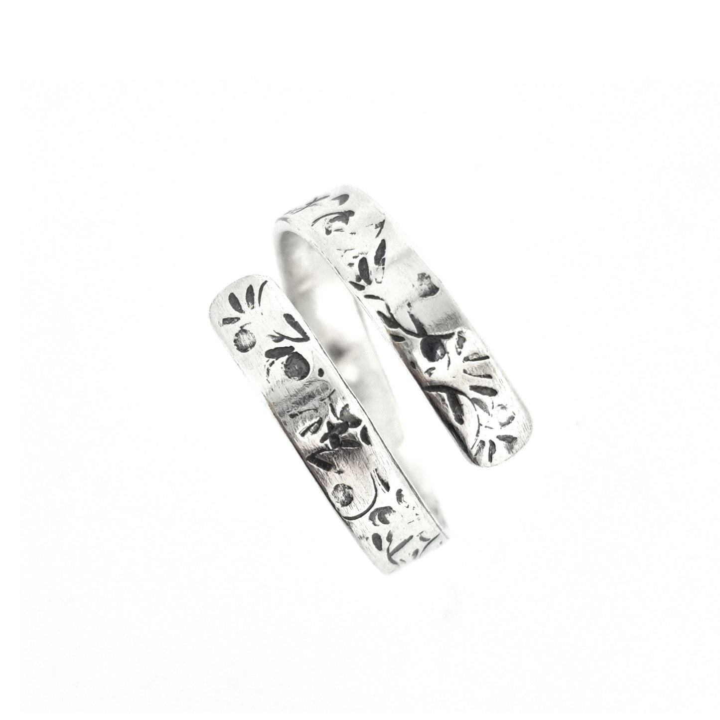 A flat silver wrap ring with leaf, bud and stalk pattern.