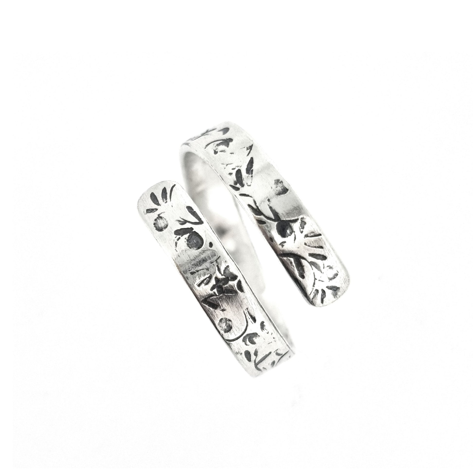 A flat silver wrap ring with leaf, bud and stalk pattern.