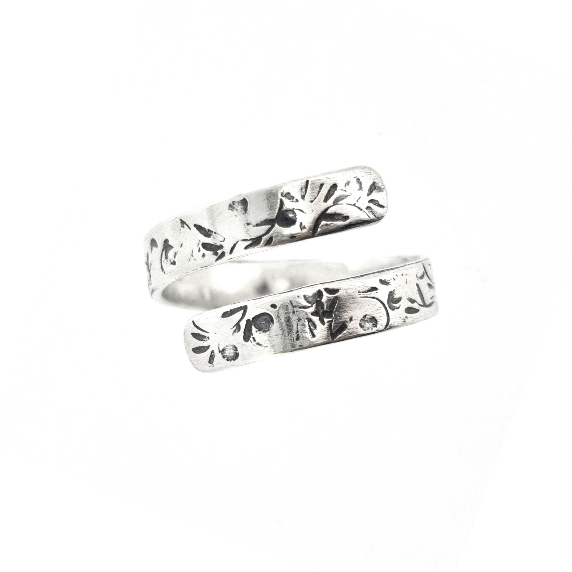 A flat silver wrap ring with leaf, bud and stalk pattern.